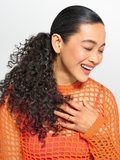 Woman with long curly hair in a pony tail